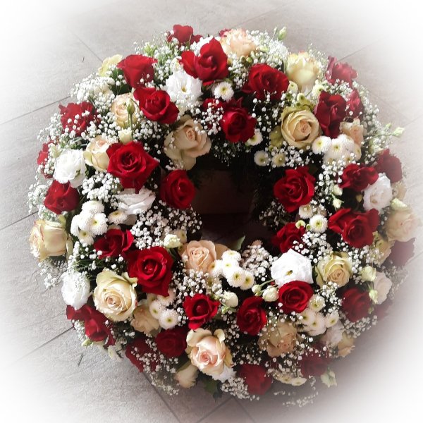 Trauerkranz mit roten Rosen und weißen Blüten Bild 1